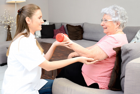 young physiotherapist nurse helping an elderly women physical rehabilitation at home